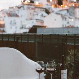 two clear wine glasses and black wine bottle